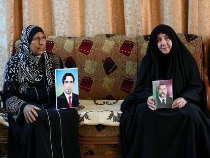 Nidal Ali, right, and Nawal Sweidan hold photos of their missing sons in Mahmoudiya, south of Baghdad, Iraq, Tuesday, March 28, 2023.