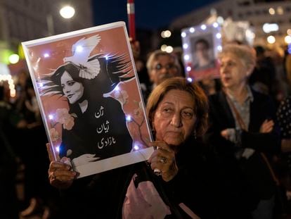 A demonstrator in Berlin holds a picture of Mahsa Amini during an evening march to commemorate the first anniversary of her death.