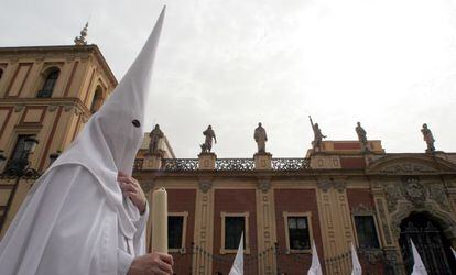 Nazarenes from the La Paz brotherhood pass by the Palacio de San Telmo, in Seville. 