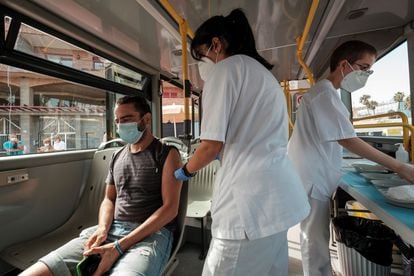 A man getting vaccinated inside the 'Vacuguagua,' a medical bus driving through the villages of Gran Canaria in search of people who have yet to get their shots. 