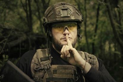 Ukrainian soldier poses for the camera with his fingers to his lips, in an undisclosed location in Ukraine