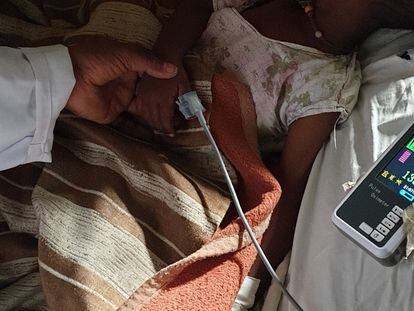 A doctor at Gambo Hospital in rural Ethiopia measures the blood oxygen level of a patient with bronchiolitis.