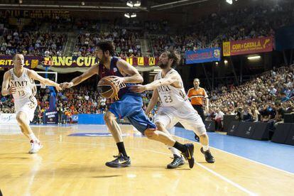 Barcelona&#039;s Navarro attempts to escape from Real Madrid player Llull.