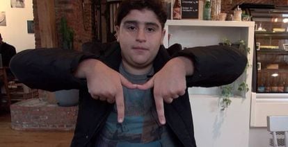 Student and rapper Aziz Benhamou makes the 'M' sign which young people in the Brussels neighborhood of Molenbeek use to identify the area.