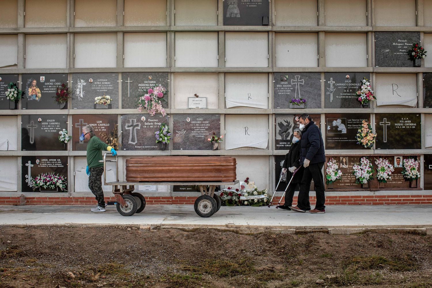 A coronavirus victim is laid to rest in Valencia, accompanied by family members.