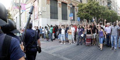 Residents of Lavapiés and members of the 15-M movement confront riot police in Valencia street.