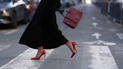 A woman walks in Paris wearing red Saint Laurent high heels.