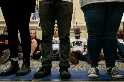 Dozens of activists stage a sit-in outside Florida Gov. Ron DeSantis' office and force people to step over them to reach DeSantis' office as they speak out against the governor and his policies