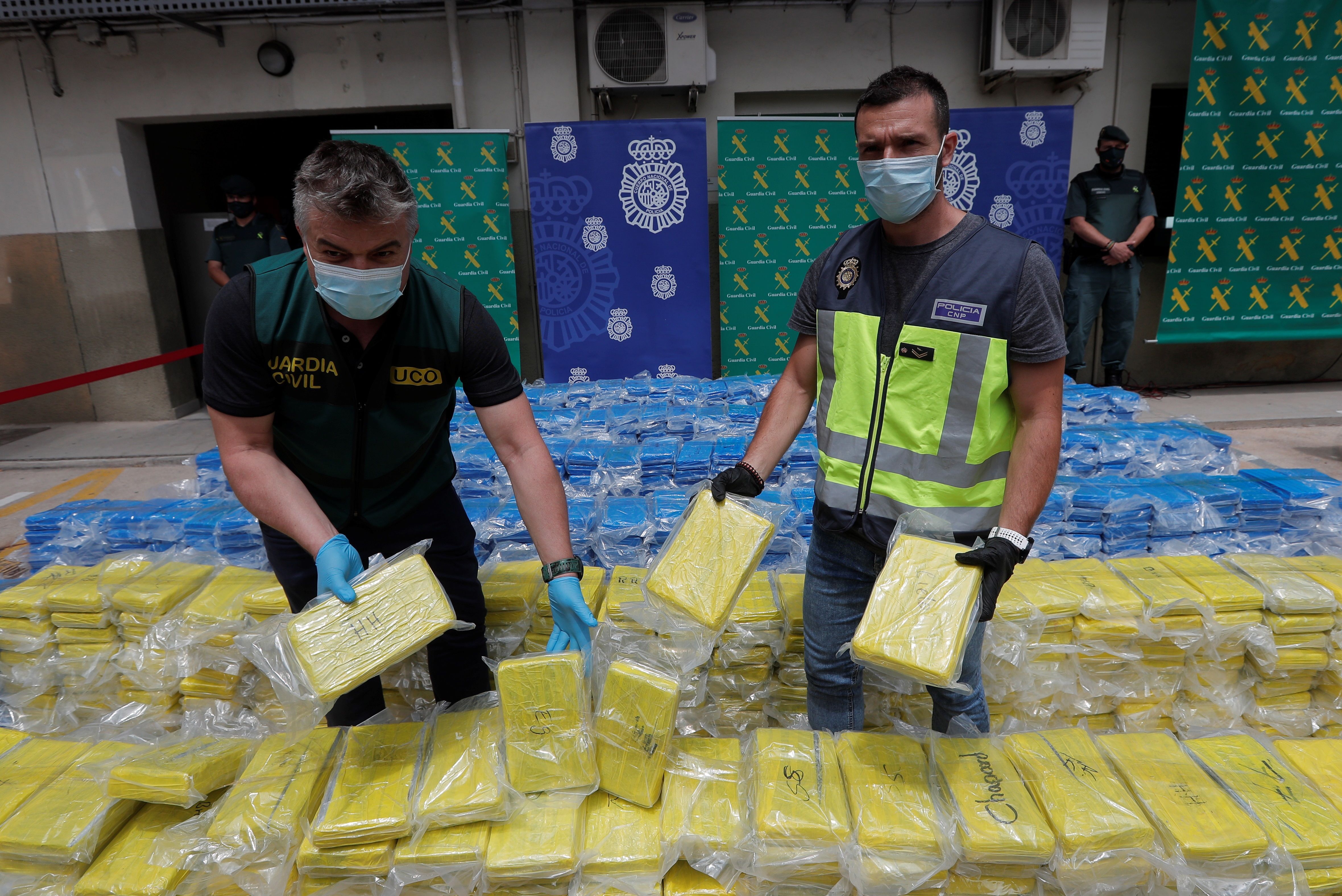 A member of UDYCO (right) and UCO (left) with 3,800 kilos of cocaine seized at the port of Valencia in a joint operation between the National Police and the Civil Guard. 