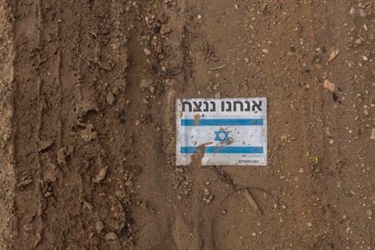 A sign with the Israeli flag and the phrase "We will conquer" near a greenhouse in the Sharsheret moshav.