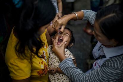A girl receives the polio vaccine in the Philippines in 2019.