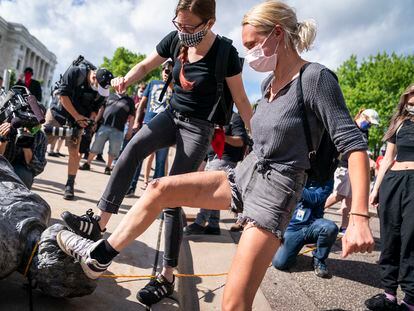 Protesters kicking a toppled Columbus statue in St. Paul, Minnesota, in June 2020.