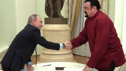 Russian President Vladimir Putin shakes hands with U.S. actor Steven Seagal in the Kremlin in Moscow, during a ceremony to award a Russian passport, Nov. 25, 2016.