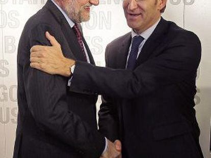 PP leader and prime minister, Mariano Rajoy (l), congratulates Galician premier Alberto N&uacute;&ntilde;ez Feij&oacute;o after the latter&#039;s re-election. 