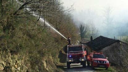 Firefighters try to put out a blaze near Vega de Pas, Cantabria.