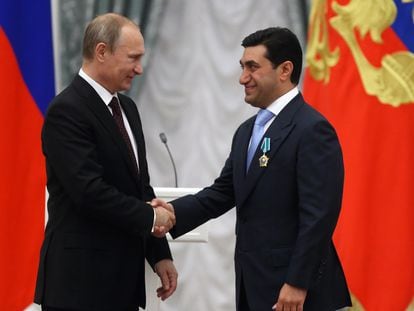 Russian President Vladimir Putin shakes hands with Russian oligarch God Nisanov on July 31, 2014 in Moscow.