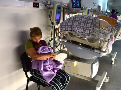 Irma Castro hugs a baby next to an incubator, in the intermediate care room of the Provincial Maternity Hospital of Córdoba, Argentina, on January 14, 2024.