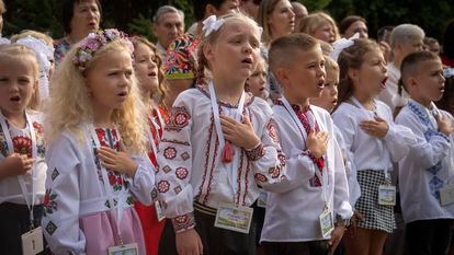 Schoolgirls sing Ukraine's national anthem as they attend a ceremony of the first day in school in Bucha, Ukraine, Friday, Sept. 1, 2023.