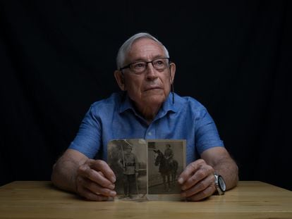 Fausto Canales poses with a photograph of the box in which his father, along with five other men and a woman, was buried in the Valley of Cuelgamuros in the late 1950s.