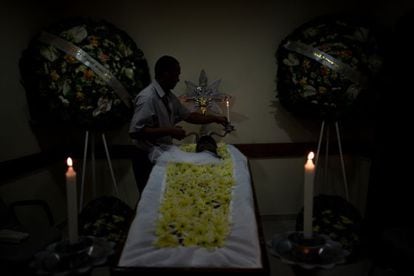 A hearse driver in São Paulo helps prepare a body for burial.