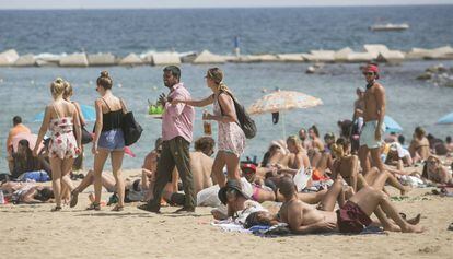 A plain clothes police officer stops a vendor on the Barceloneta beach on Wednesday.