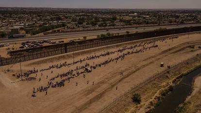 Hundreds of migrants wait near the border after crossing the Rio Grande, in Ciudad Juárez.
