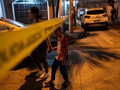 Residents of Durán (Ecuador) pass the tape that surrounds a crime scene to get home, on September 28, 2023.