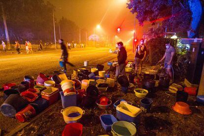 Young people prepare buckets of water to fight the fire in Coia neighborhood of Vigo.
