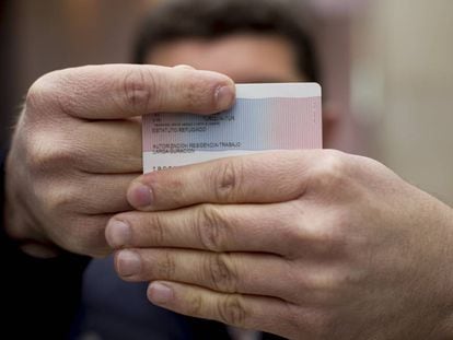 The first Turkish citizen granted political asylum in Spain shows his refugee ID card.