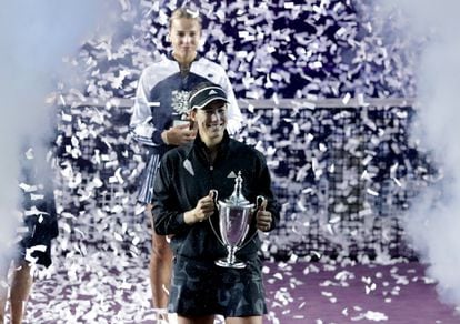 Garbiñe Muguruza holds her trophy, while Anett Kontaveit stands with the runner-up prize.