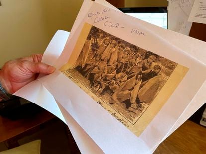 A history teacher looks at a photo of a 19th century Native American boarding school in Santa Fe.