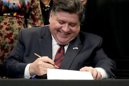 Illinois Governor J.B. Pritzker signs into law the Paid Leave For All Workers Act on March 13, 2023, in Chicago.