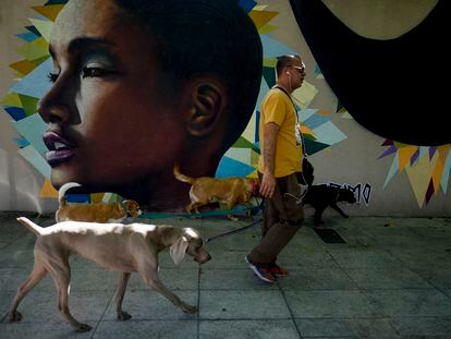 A man walks past a mural of a young Afro-Argentine woman in Buenos Aires in November 2021.
