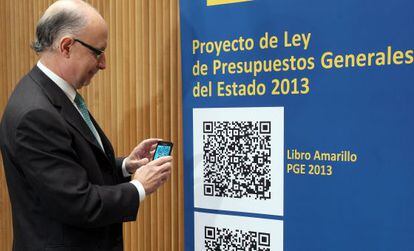 Finance Minister Crist&oacute;bal Montoro poses with a QR-Code version of the 2013 draft state budget.