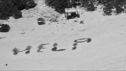 The distress message written by shipwrecked mariners with palm leaves on the beach of an atoll in Micronesia.