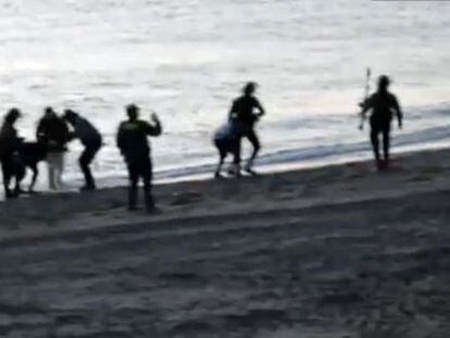 Civil Guard officers return undocumented migrants to Morocco at Tarajal beach.