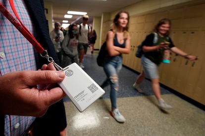 The security director of a Kansas school displays a panic button to be used in an emergency.