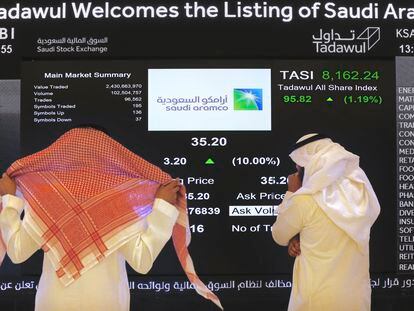 Saudi stock market operators follow the price of the Aramco oil company on a screen, one of the companies owned by the sovereign wealth fund of the Arab country.