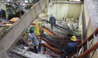 Workers sift through the blast site on Tuesday.