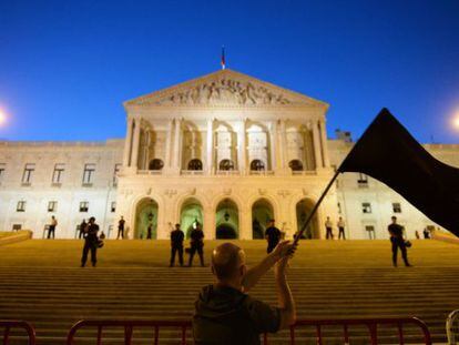A protestor waves a black flag during a demonstration in front of the parliament building in Lisbon on Saturday.