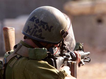 An Israeli soldier aims his M-16 rifle at Palestinians throwing rocks in Bethlehem, in 2000. 