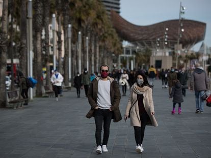 People wearing masks on the seaside promenade in Barcelona.