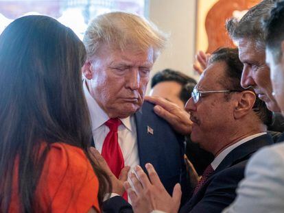 Former President Donald Trump prays with pastor Mario Bramnick, third from right, and others at Versailles restaurant on Tuesday, June 13, 2023, in Miami.