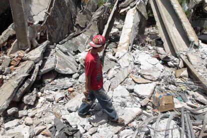 A boy inspects ruins from a building that collapsed in 1972 and was damaged again by last week's quake.