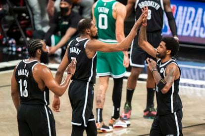 Brooklyn Nets guard James Harden (13), forward Kevin Durant (7) and guard Kyrie Irving celebrate during the first half of Game 1 of an NBA basketball first-round playoff series Saturday, May 22, 2021, in New York.