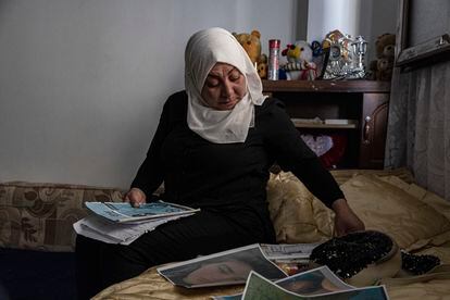 Hamrin Alouji, the mother of 13-year-old Peyal Aqil, goes through her daughter's photographs at their family home in Qamishli, Syria