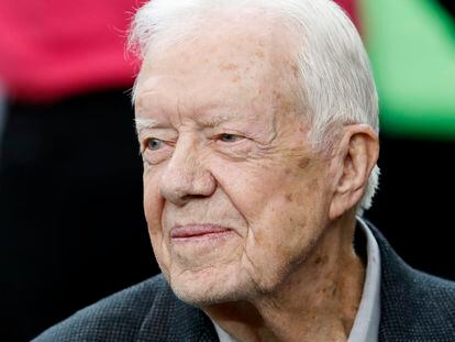 Former President Jimmy Carter sits on the Atlanta Falcons bench before the first half of an NFL football game between the Atlanta Falcons and the San Diego Chargers, Oct. 23, 2016, in Atlanta.
