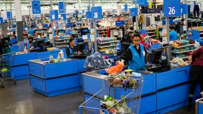 Cashiers process purchases at a Walmart Supercenter in North Bergen, N.J., on Feb. 9, 2023.