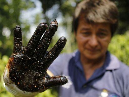 Activist Donald Moncayo shows the pollution from a lake in 2011.