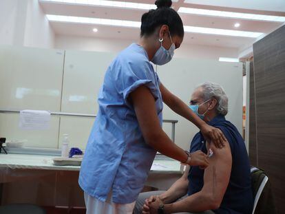 A nurse vaccinates Madrid‘s health chief Enrique Ruiz Escudero at Puerta de Hierro hospital in Majadahonda.